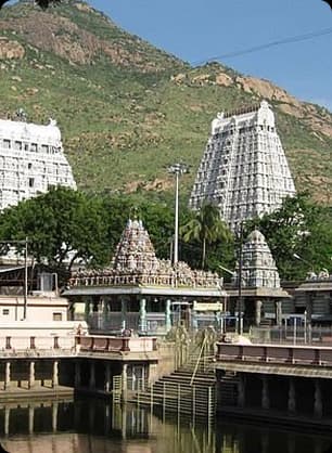 Ettukai Amman Temple situated at the base of the hills with its tall gopurams and peaceful natural backdrop.