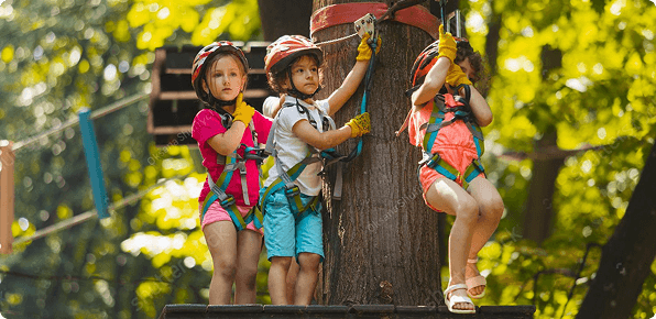 Kids enjoying outdoor climbing and play activities in a safe adventure zone surrounded by nature.