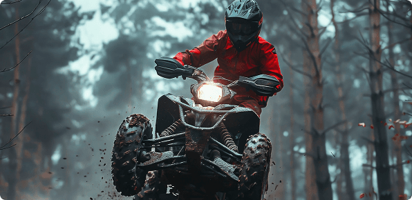 ATV rider navigating rough forest terrain with mud, speed and thrill in an off-road adventure trail.