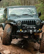 A rugged off road vehicle driving through a forest trail offering a thrilling adventure experience.