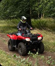 Participant riding a quad bike on an outdoor dirt track during an exciting time trial activity.