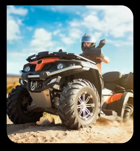 A rider driving an off-road ATV across sandy terrain at an adventure amusement park near Kolli Hills