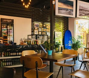Interior of a cozy café showcasing partner branding with seating and decorative visitor displays.