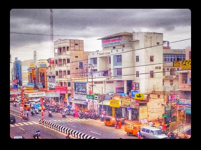Busy Karur Town Street With Shops and Daily Local Activity A vibrant street scene in Karur showing shops, traffic, and colorful buildings capturing the town’s daily life