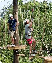 High Altitude Vertical Challenge Course for Team Adventure Fun Two people climbing rope elements on a vertical challenge course designed for teamwork and courage.