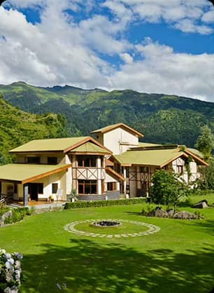 Scenic Hillside Green Resort View Near Forested Mountains Green hillside resort surrounded by lush lawns and forested mountains creating a calm nature stay